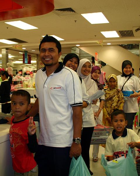 The volunteers of UMW Toyota Motor lining up at the cashier together with the children